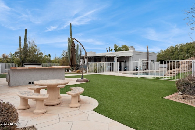 view of community featuring a yard, a swimming pool, and a patio