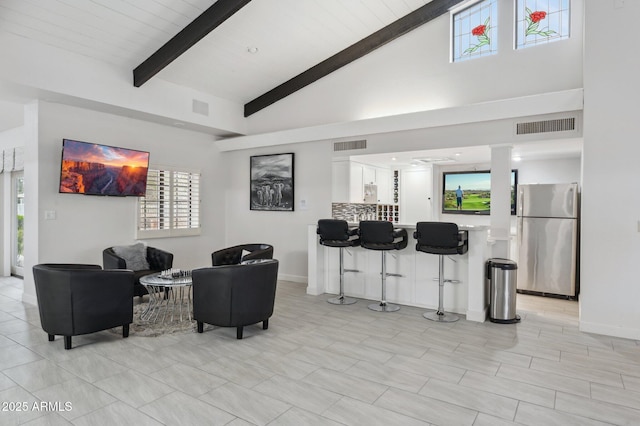 living room featuring beamed ceiling and high vaulted ceiling