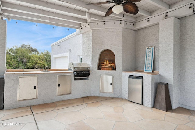 view of patio featuring exterior kitchen, ceiling fan, and grilling area