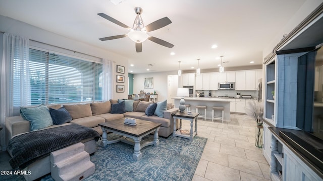 living room with ceiling fan and light tile patterned flooring