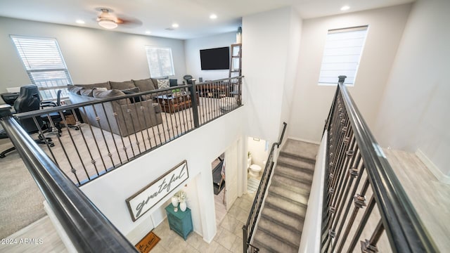 staircase featuring ceiling fan