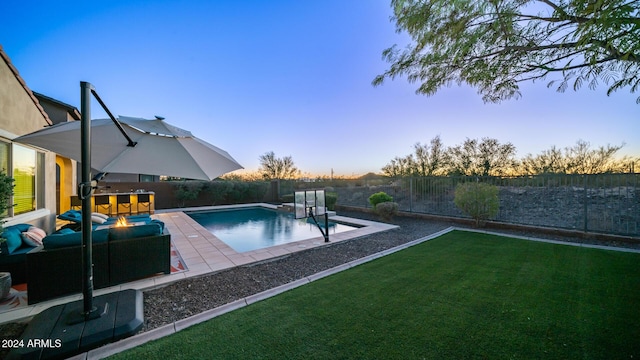 pool at dusk with a lawn, an outdoor living space, and a patio