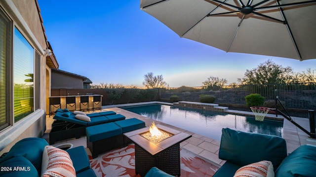 view of pool with a bar, a fire pit, and a patio area