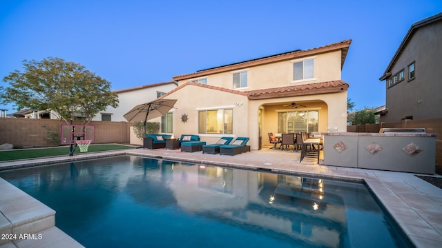 back of property featuring outdoor lounge area, ceiling fan, a patio, a fenced in pool, and an outdoor bar