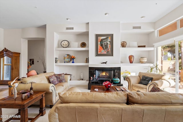 living room featuring a fireplace and built in features