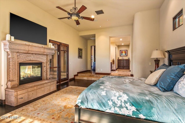 bedroom with visible vents, baseboards, a premium fireplace, recessed lighting, and wood finished floors