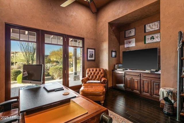 office space with a high ceiling, dark wood-style flooring, a wealth of natural light, and ceiling fan