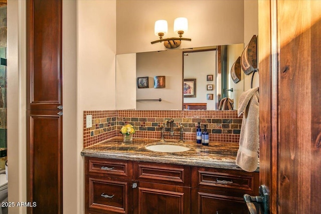 bathroom featuring tasteful backsplash, vanity, and toilet