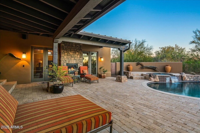 view of patio featuring french doors, a fenced in pool, and an in ground hot tub