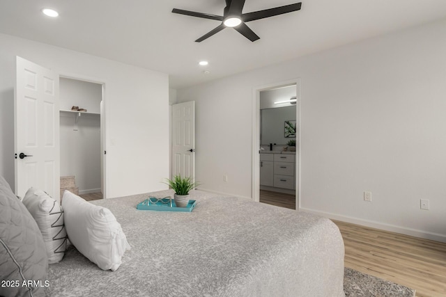 10625 E Bramble Ave, Mesa, AZ 85208 - bedroom featuring wood finished floors, baseboards, recessed lighting, connected bathroom, and a walk in closet