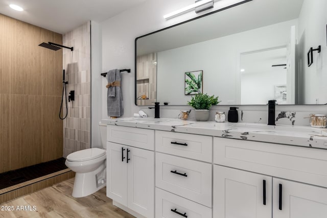 10625 E Bramble Ave, Mesa, AZ 85208 - full bathroom featuring double vanity, toilet, a tile shower, wood finished floors, and recessed lighting