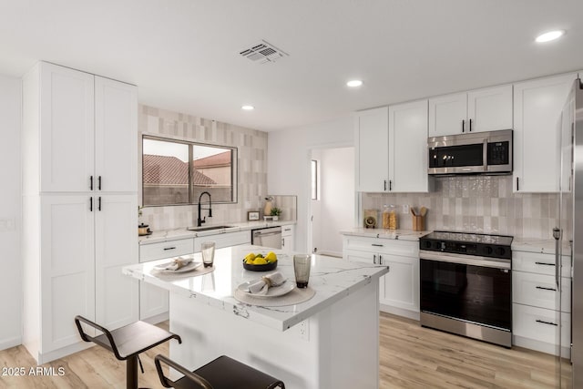 10625 E Bramble Ave, Mesa, AZ 85208 - kitchen with appliances with stainless steel finishes, a sink, tasteful backsplash, light wood-style floors, and recessed lighting