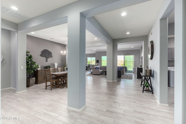 foyer with light hardwood / wood-style flooring and a chandelier