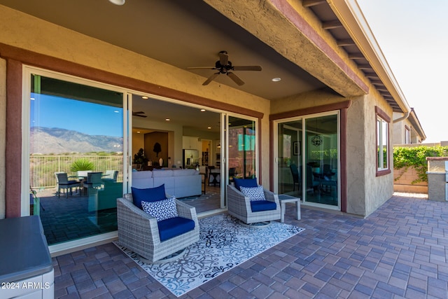 view of patio / terrace with an outdoor hangout area, a mountain view, and ceiling fan