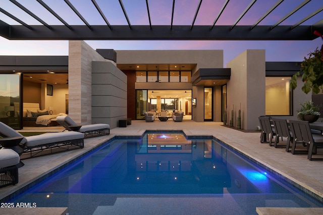 pool at dusk with an outdoor living space and a patio