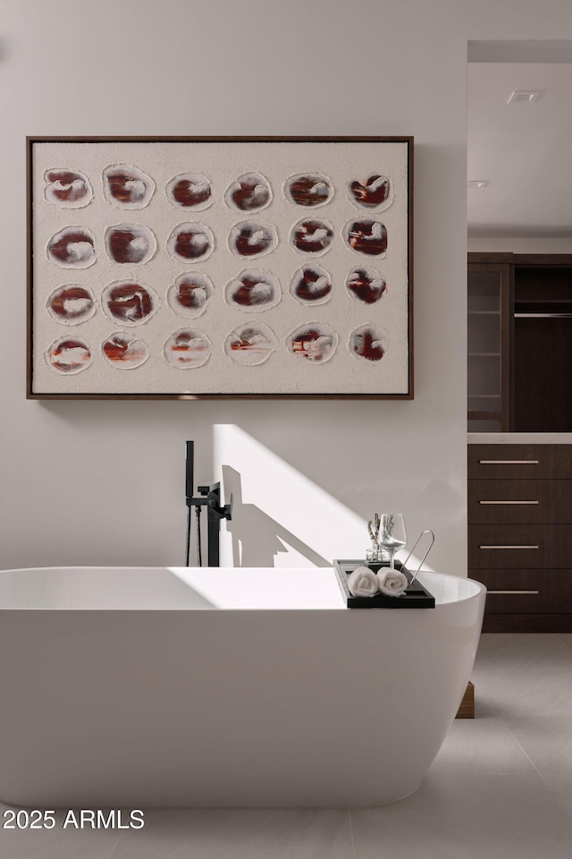 bathroom with a tub to relax in and tile patterned flooring