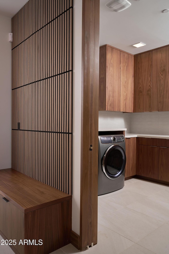 laundry room featuring cabinets, washer / clothes dryer, and light tile patterned flooring