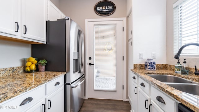 kitchen featuring dark hardwood / wood-style flooring, white cabinetry, sink, and light stone counters