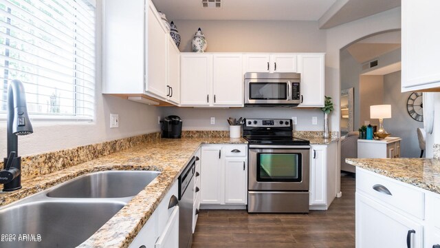 kitchen with white cabinets, appliances with stainless steel finishes, dark hardwood / wood-style floors, and sink