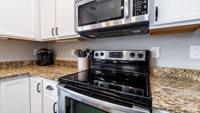 kitchen with white cabinets, light stone countertops, and stainless steel appliances