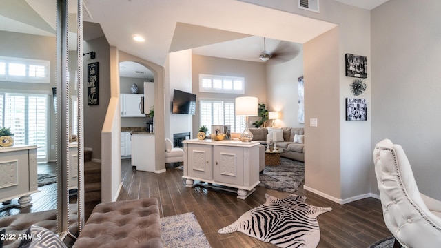 interior space with ceiling fan, dark hardwood / wood-style flooring, and a high ceiling