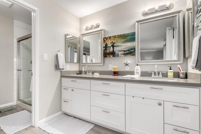 full bathroom featuring double vanity, a shower stall, visible vents, and a sink