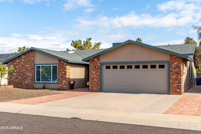 view of front of house featuring a garage, driveway, roof with shingles, and brick siding