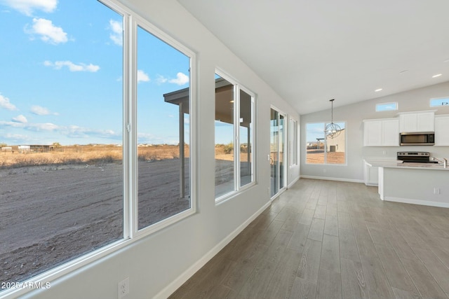 22343 S Manzanilla Rd, Buckeye, AZ 85326 - unfurnished sunroom with wood finished floors, lofted ceiling, and a chandelier