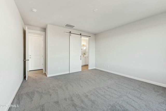 22343 S Manzanilla Rd, Buckeye, AZ 85326 - unfurnished bedroom with carpet floors, a barn door, and ensuite bathroom