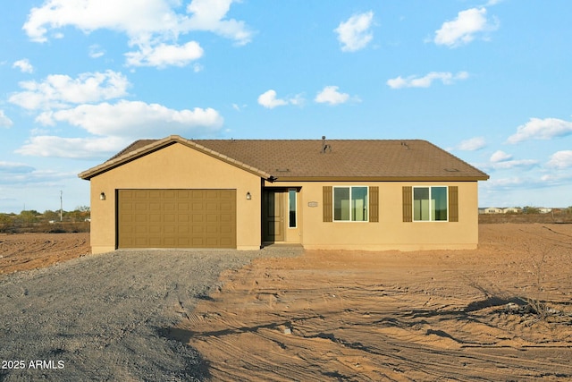 22343 S Manzanilla Rd, Buckeye, AZ 85326 - ranch-style home with dirt driveway, an attached garage, and stucco siding