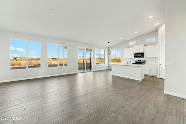 22343 S Manzanilla Rd, Buckeye, AZ 85326 - unfurnished living room with wood finished floors, recessed lighting, and high vaulted ceiling