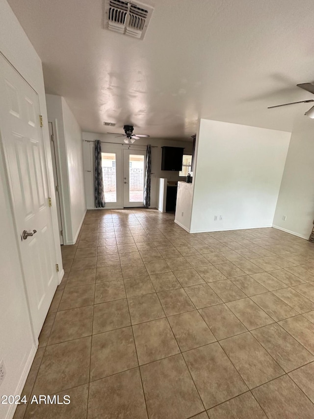 unfurnished living room featuring tile patterned floors, french doors, and ceiling fan