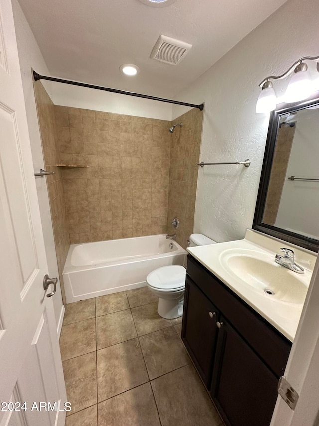 full bathroom featuring vanity, tiled shower / bath, tile patterned flooring, and toilet