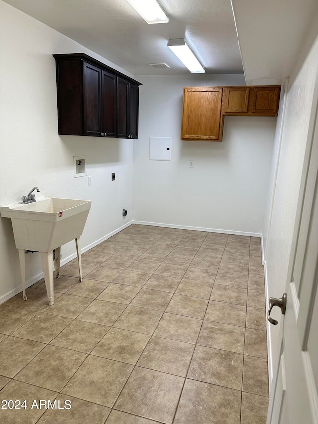 washroom with cabinets, light tile patterned flooring, hookup for an electric dryer, and washer hookup