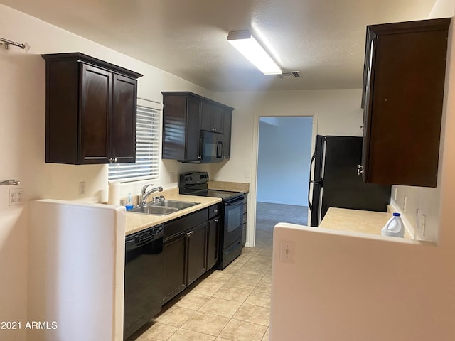 kitchen with light tile patterned flooring, black appliances, dark brown cabinetry, and sink