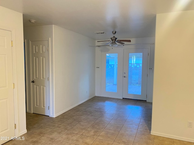 empty room with light tile patterned flooring, ceiling fan, and french doors