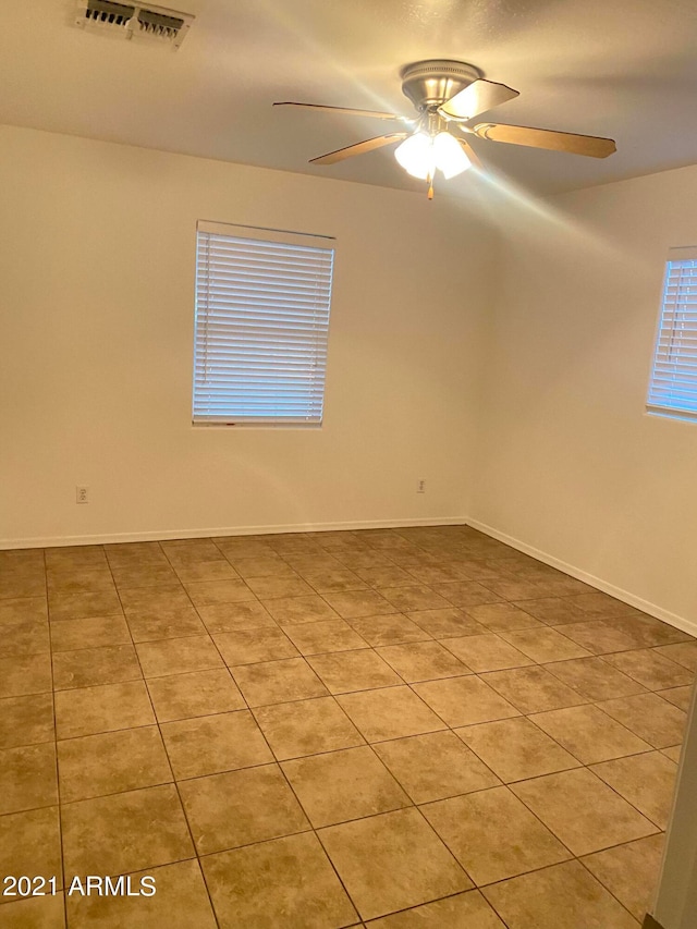 empty room with light tile patterned floors and ceiling fan