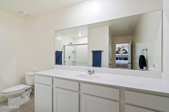 bathroom featuring vanity, toilet, tile patterned floors, and a shower with shower door