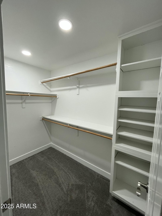 spacious closet featuring dark carpet