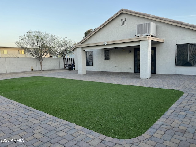 back of property with a patio, fence, a yard, stucco siding, and central air condition unit