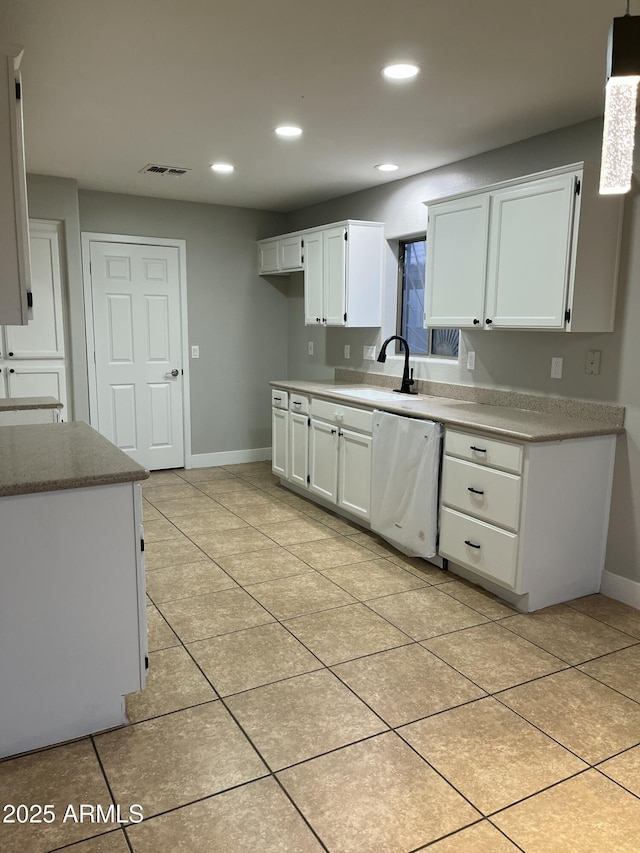 kitchen featuring visible vents, white cabinets, dishwasher, and a sink