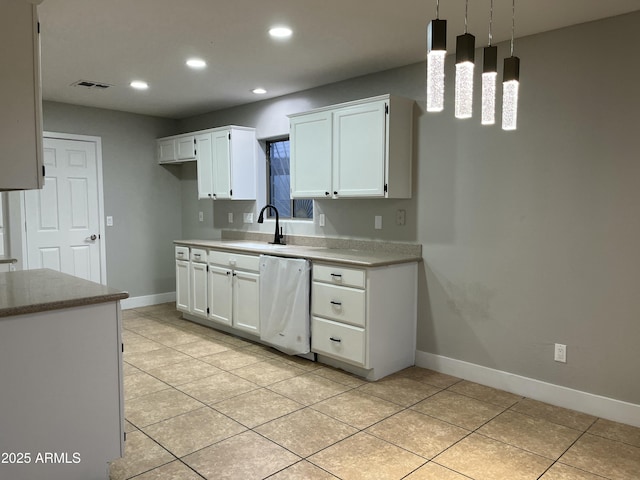 kitchen with visible vents, light tile patterned floors, dishwashing machine, white cabinetry, and a sink