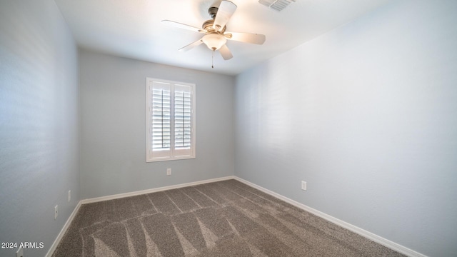 unfurnished room with ceiling fan and dark colored carpet