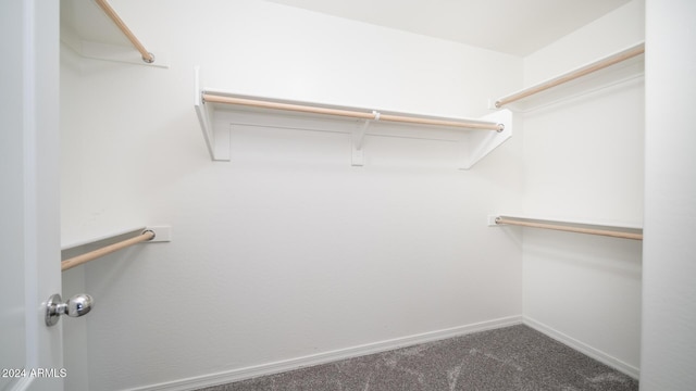 spacious closet featuring dark carpet