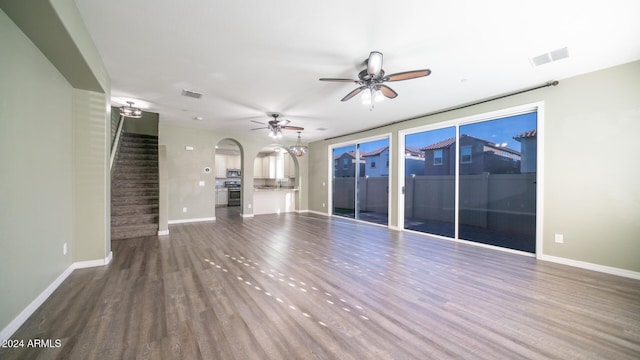 unfurnished living room with dark hardwood / wood-style flooring and ceiling fan