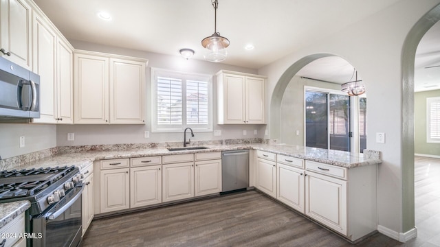 kitchen featuring pendant lighting, white cabinetry, sink, and stainless steel appliances