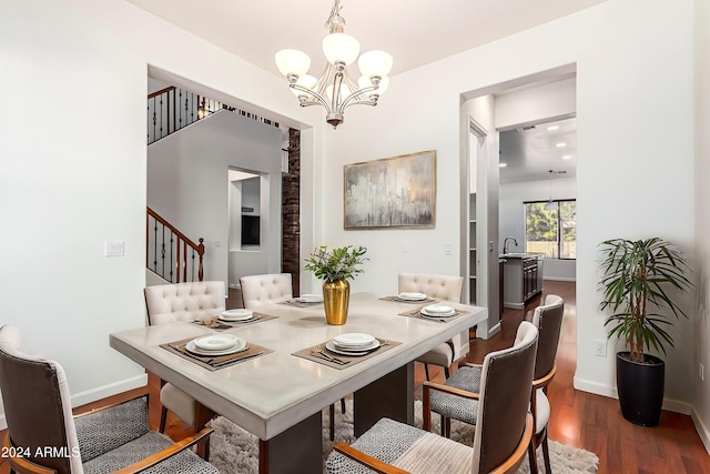 dining area featuring sink, dark wood-type flooring, and a notable chandelier