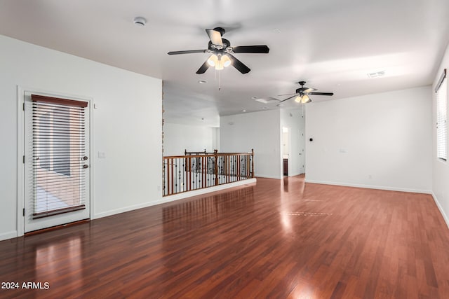 empty room with dark hardwood / wood-style floors and ceiling fan