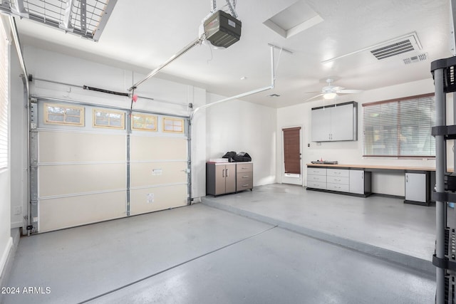 garage with a garage door opener, a workshop area, and ceiling fan