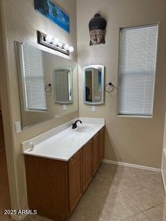 full bath with baseboards, tile patterned floors, a tub, and vanity